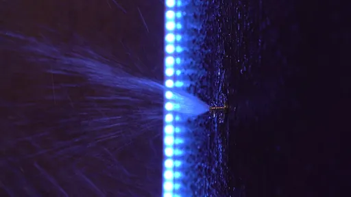 Вертикальная LED-лента и вода из лейки на тёмной поверхности